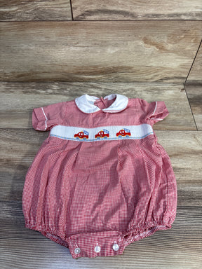 Top down view of red gingham baby bubble romper with white Peter Pan collar and smocked firetruck embroidery on wood floor