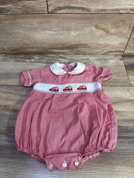 Top down view of red gingham baby bubble romper with white Peter Pan collar and smocked firetruck embroidery on wood floor