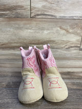 Front view of Stepping Stones baby cowgirl crib boots in pink and tan, embroidered upper and suede-look toe on wood floor