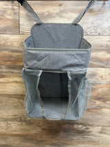 Front view of Maliton hanging diaper caddy with open main compartment and mesh side pockets on wood background