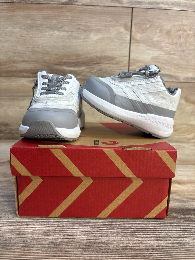 Gray and white kids athletic sneakers on a red shoe box, wooden background