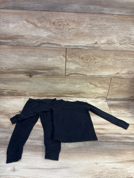 Top-down view of black Carter’s two-piece skeleton print pajama set with long-sleeve top and matching pants on wood-look floor