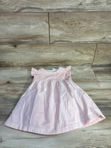 Top-down view of pink eyelet toddler dress 18 months showing eyelet bodice and flutter sleeves on wood floor background