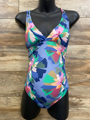 Front view of blue floral maternity swimsuit, V-neck with strappy shoulders and side ruching on mannequin, wood background