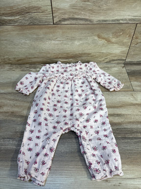 Long sleeve baby romper with pink floral pattern on wood background