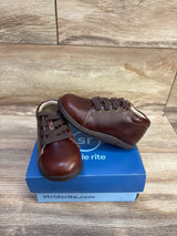 Three quarter view of Stride Rite SRTech Elliot toddler brown leather sneakers showing lace-up closure and cushioned sole on blue shoebox