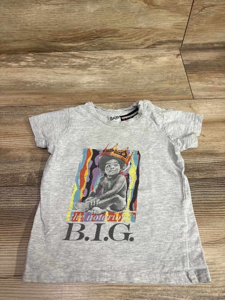 Front view of grey Cotton On Baby The Notorious BIG shirt in size 12 to 18 months with crowned baby graphic on wood floor