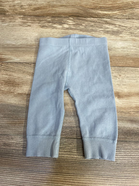 Flat lay of Hanna Andersson light blue ribbed leggings showing waistband and cuffed ankles on wood background