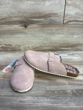 Pink suede slip-on clogs for kids with buckle detail on wood background