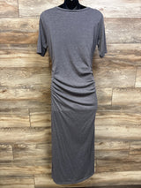 Back view of a grey Motherhood Maternity bodycon dress on a mannequin against a wood wall.