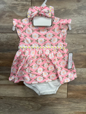 Pink floral baby romper dress with matching headband on wooden background