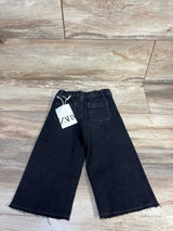 Back view of black Zara toddler wide-leg jeans (18–24m) showing frayed hems, elastic waistband and Zara tag on wood floor