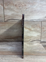 Spine of children's book Training Up a Little Guy by Jim Daly displayed vertically on wood tile background