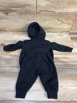 Black Nike 2-piece zip-up hoodie and joggers set for baby size 3m on a wood background