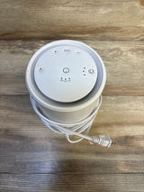 White sound machine with multiple buttons and power cord, on wood surface