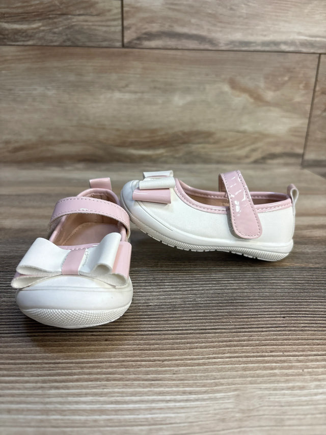 White and pink baby girl shoes with bows and velcro straps on wooden background