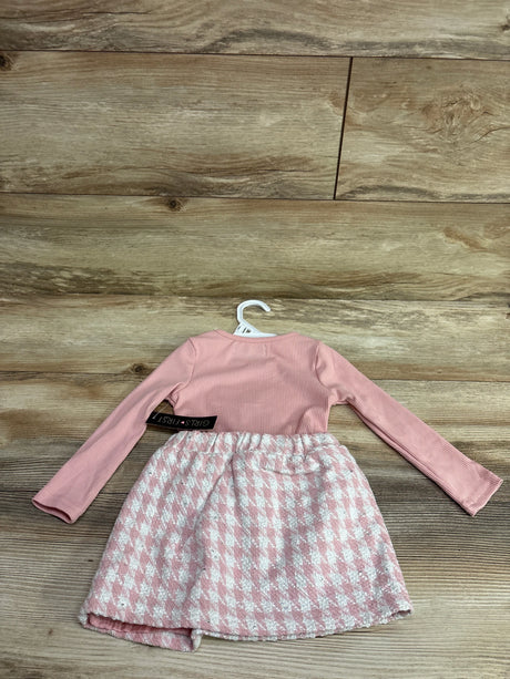Back view of pink long sleeve tartan skirt dress showcasing patterned skirt on a hanger against a wood floor