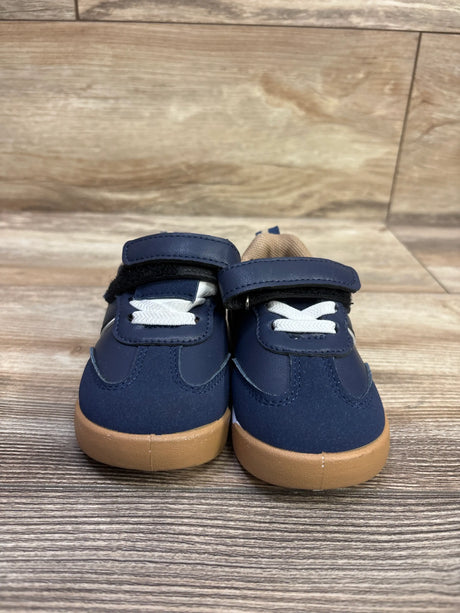 Front view of Josmo navy hook-and-loop sneakers showcasing white laces and tan soles with a wood-look background