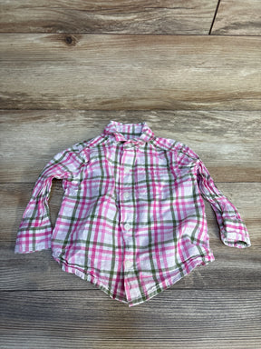 Pink and green plaid long sleeve button-up toddler shirt on wood background