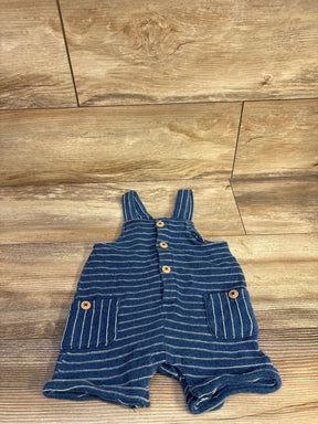 Flat lay of blue Cat & Jack striped henley shortalls showcasing front button placket and two patch pockets with wooden-look buttons on wood floor background