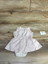 Flat lay of Cloud Island pink tank dress and white bloomers (0-3M) showing ruffled neckline and bow on wood background