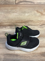Black and green Skechers toddler shoes with velcro straps on wood background