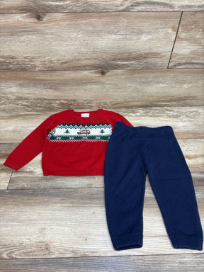 Top view of First Impressions two piece Christmas sweater and pants set in red and navy with festive knit pattern on wood