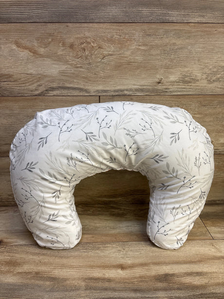 Top view of Boppy nursing pillow with botanical leaf slipcover showcasing its U-shaped design on a wood background