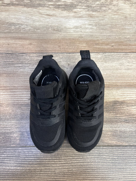 Top-down view of Adidas Multix I toddler black sneakers showing mesh upper, three stripes, and laces on light wood floor