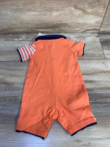 Back view of orange shortie polo romper (0-3M) showing navy collar and cuffs and striped sleeve on wood background