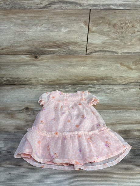 Flat lay of pink Just One You baby dress and matching bloomers showcasing floral print, puff sleeves and ruffled tiered hem on wood floor background