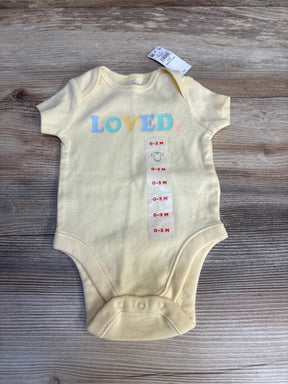 Yellow baby onesie with 'LOVED' text, size 0-3 months, displayed on wood background