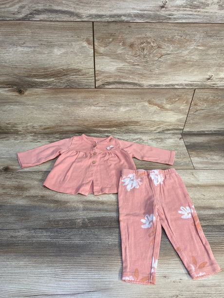 Pink baby outfit set with long sleeve top and floral pants on wood background