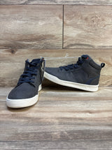 Pair of navy blue high-top kids sneakers with white soles on wood floor
