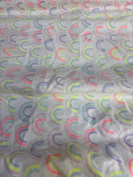 Angled view of Cloud Island fitted crib sheet showcasing rainbow print on white background