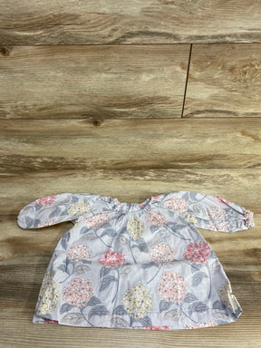 Floral baby dress with long sleeves in pastel pink, yellow and gray on wood floor
