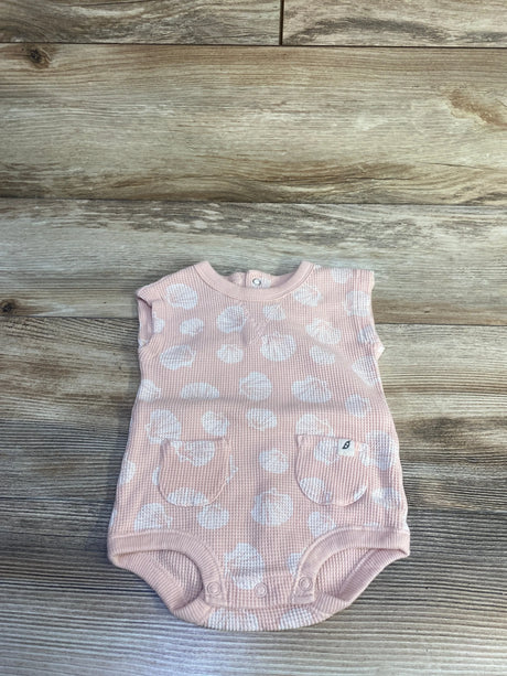 Top-down view of peach waffle-knit baby tank bodysuit (size 3–6m) with white polka dots, two front patch pockets, and crotch snaps on wood plank background