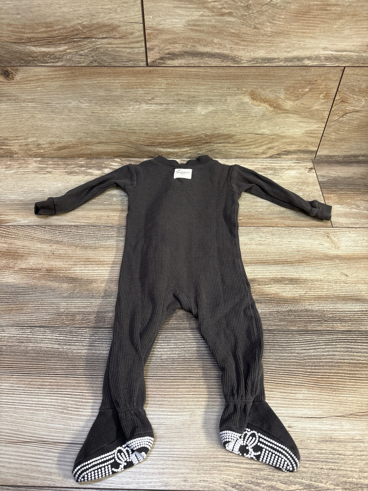 Front view of Burt’s Bees Baby grey waffle knit sleeper showcasing long sleeves and grippy footed soles on a wood floor
