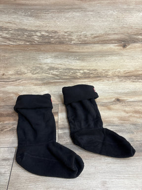 Pair of black fleece toddler socks with folded cuffs on wooden surface