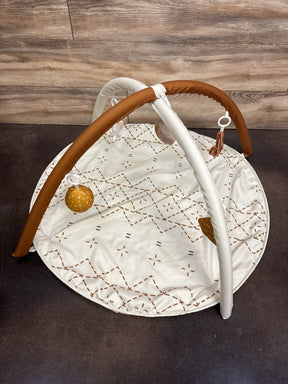Baby play gym with soft mat, hanging toys, and wooden arches on brown background