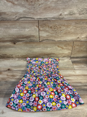 Colorful floral print toddler dress with smocked bodice on wood background