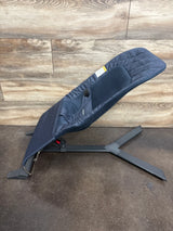 Navy blue baby bouncer seat with metal frame on wood and dark floor background