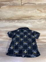 Flat lay of newborn black Old Navy linen blend button up shirt with short sleeves and white and gold floral grid on wood background