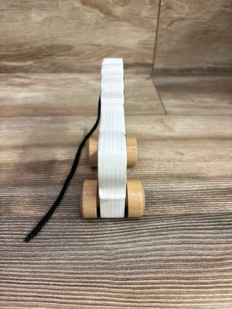 Side view of Hape Wooden Push & Pull Zebra showcasing its wooden wheels and pull cord on a wood floor