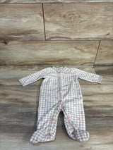 Flat lay of Carter's beige gingham baby sleeper with cherry print, front snap closure and built-in footies on wood background