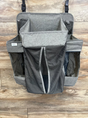 Gray hanging diaper caddy organizer with mesh pockets on wood background