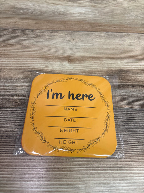 Front view of 12-piece monthly milestone photo prop cards showing an I’m here card with name, date, weight, and height fields