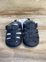 Black toddler leather sandals with closed toe on wooden background