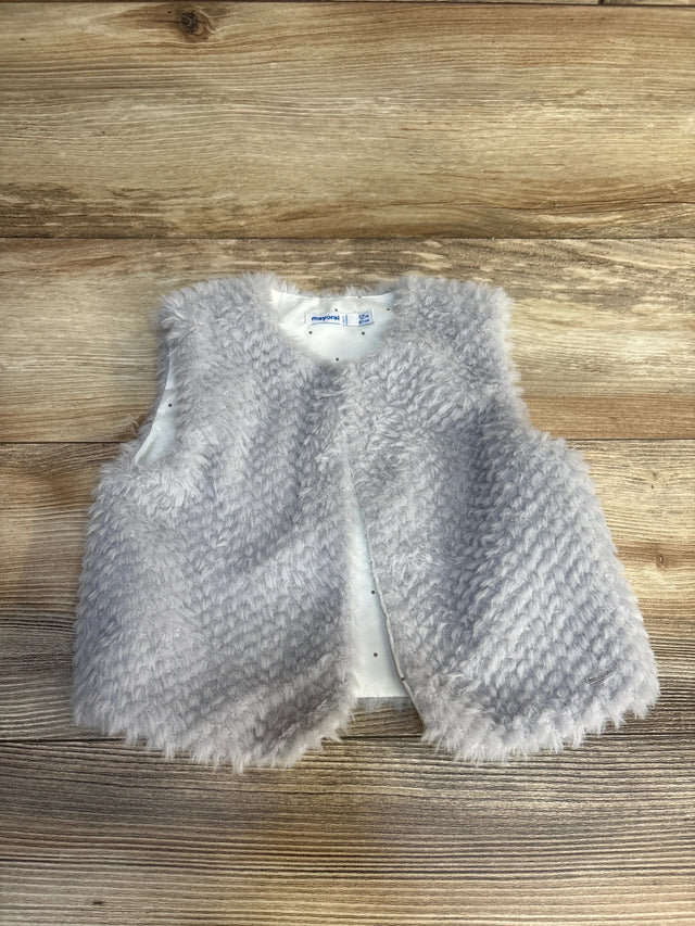 Gray fuzzy baby vest for 12 months, soft faux fur toddler outerwear on wood background