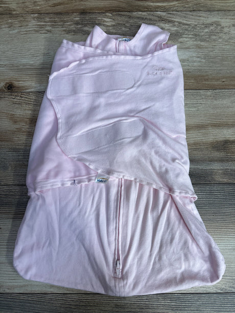 Light pink baby swaddle blanket with zipper and wing-like fasteners on wood surface